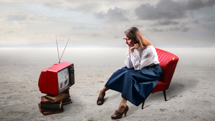 Frau schaut auf einem Fernseher mit Antenne fern