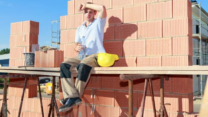Bauarbeiter arbeitet in der prallen Sonne.