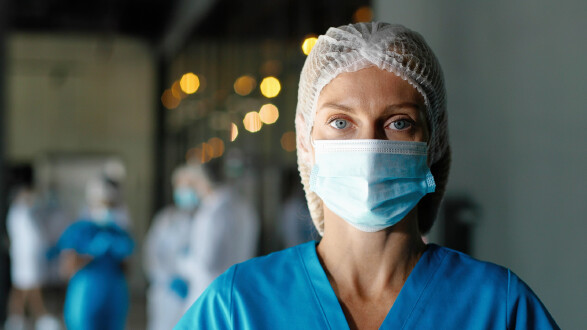 Pflegerin mit Maske schaut in die Kamera. © VAKSMANV, stock.adobe.com