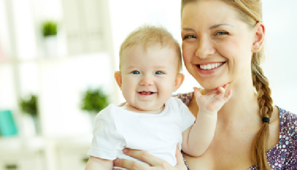 Frau hält ein fröhliches Baby in den Armen. © pressmaster, fotolia.com