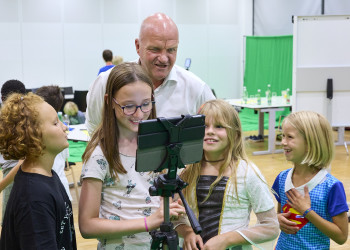 AK Niederösterreich Präsident Markus Wieser und Kinder schauen auf ein ipad und haben Spaß 