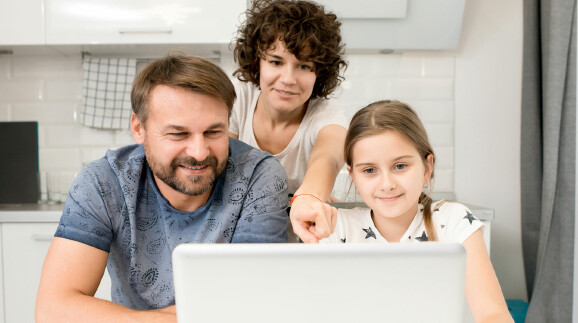 Familie schaut gemeinsam auf den Computer.