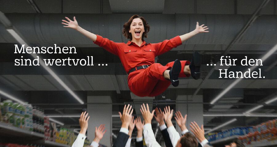Eine grinsende Handelsangestellte wird von einer Gruppe von Menschen in die Luft geworfen. Dabei steht der Text "Menschen sind wertvoll f&uuml;r den Handel."