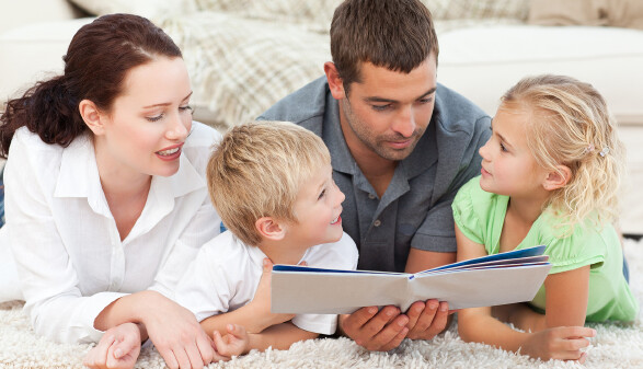 Familie schaut ins Fotobuch