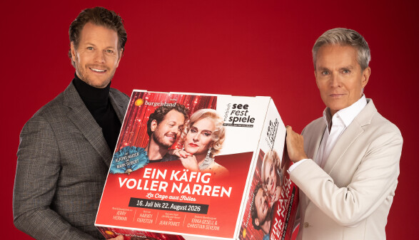 Die Hauptdarsteller halten einen W&uuml;rfel mit dem Sujet des St&uuml;cks.