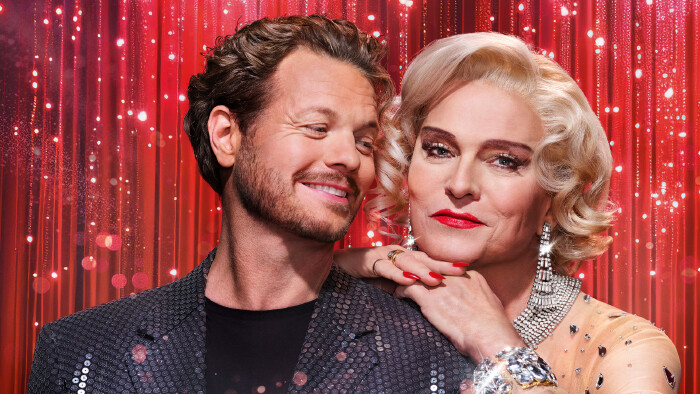 zwei Hauptfiguren vor rotem Vorhang